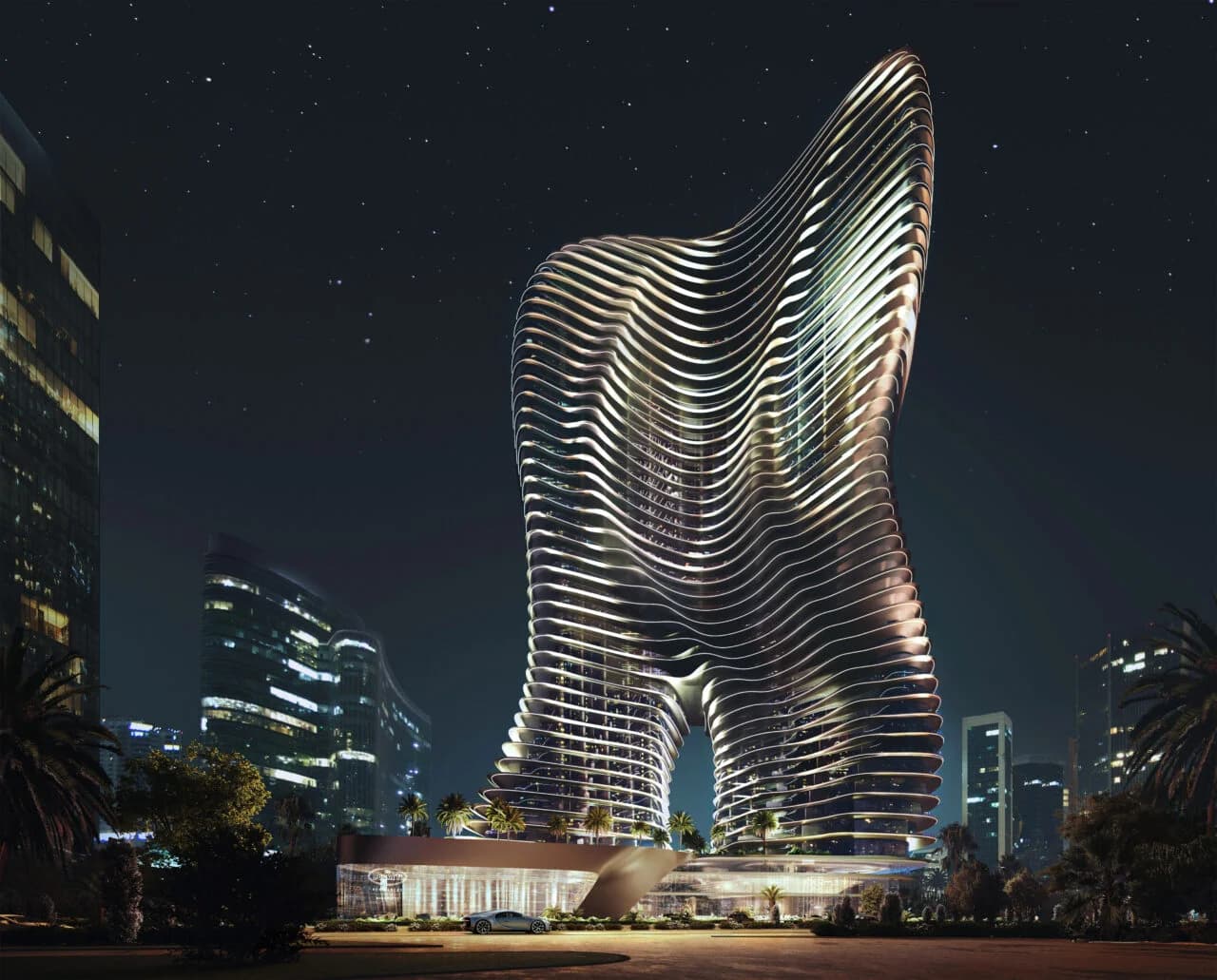 Bugatti Residence by Binghatti at night: a sculpted high-rise with flowing vertical fins, lit against the Business Bay skyline.
